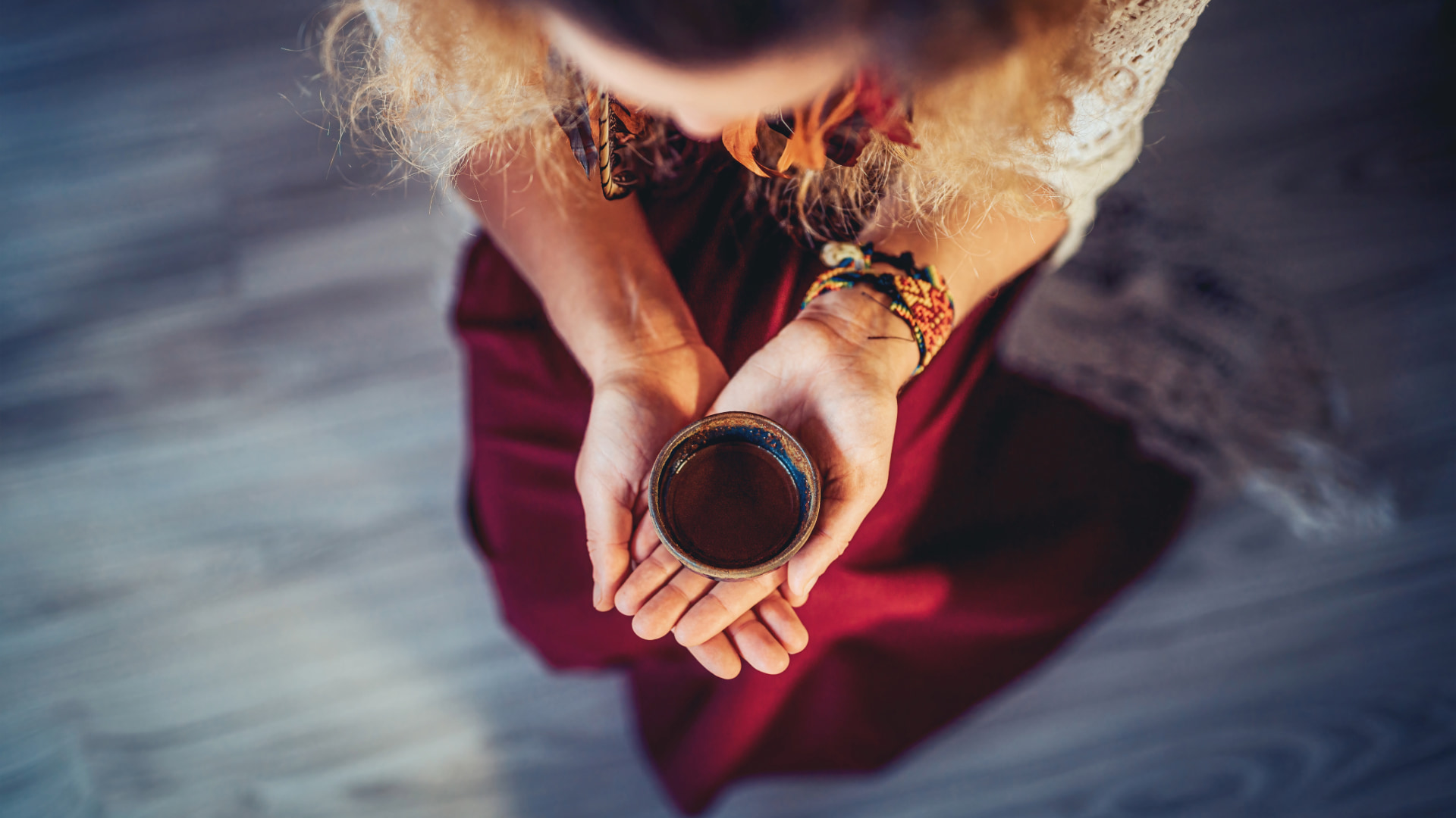 Person holding a ceremonial cup in a traditional healing ritual, focusing on spirituality and inner connection.