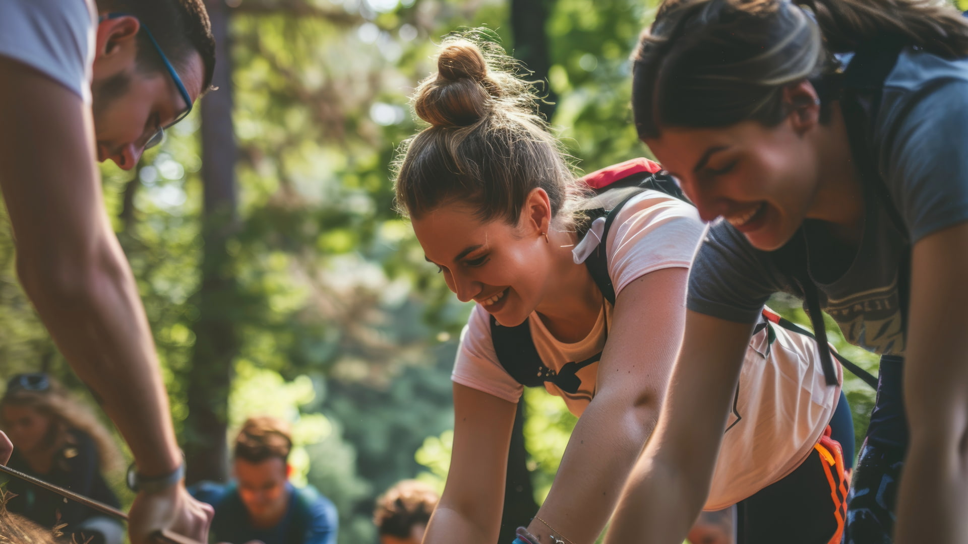 Group of young friends smiling and working together outdoors, surrounded by greenery, capturing a moment of teamwork and connection with nature during an adventure.